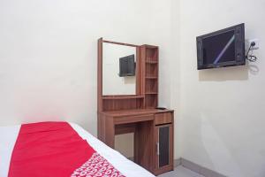 a bedroom with a mirror and a tv and a bed at SUPER OYO Capital O 91790 S1 Residence in Tangerang
