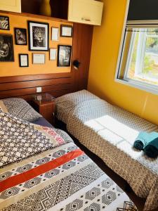 two beds in a room with a window at Joli Mobil-Home de Vacances, Ideal pour les familles in Rocbaron