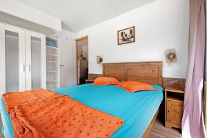 een slaapkamer met een blauw bed met oranje kussens bij Nido sobre el barranco piso Bali in Icod de los Vinos