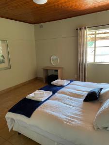 a bedroom with a large bed with two pillows on it at Enon in Haenertsburg