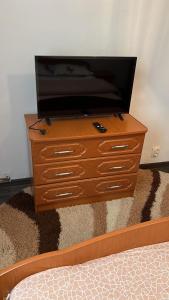 a wooden dresser with a television on top of it at LA ALIS SI RAISA! Apartament cu 2 camere! in Lupeni