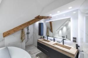 ein Badezimmer mit einem Waschbecken und einem großen Spiegel in der Unterkunft Mairnaige, luxueux appartement avec sauna in Gérardmer
