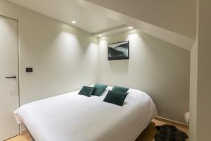 a bedroom with a large white bed with two pillows at Mairnaige, luxueux appartement avec sauna in Gérardmer +10 photos