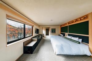 een slaapkamer met een groot bed en een groot raam bij Hotel Alza Kyoto in Kyoto