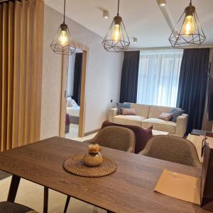 a living room with a table and chairs and a living room at Select Lux Woodside Residences & SPA in Kopaonik +16 photos