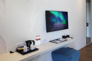 Cette chambre dispose d'un bureau avec une chaise bleue et d'une télévision. dans l'établissement Bromo Park Hotel Probolinggo, à Probolinggo