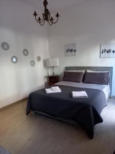 sypialnia z dużym łóżkiem i żyrandolem w obiekcie Maxim w mieście Sammichele di Bari