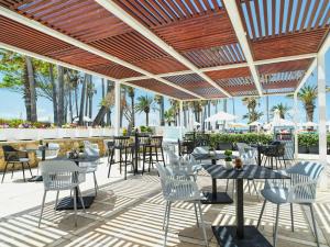 a patio at a restaurant with tables and chairs at Leonardo Plaza Cypria Maris Beach Hotel & Spa in Paphos City