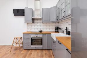 una cucina con elettrodomestici bianchi e pavimenti in legno di Radziwiłłowska Apartment Cracow Planty by Renters a Cracovia