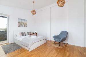 una camera bianca con un letto e una sedia di Radziwiłłowska Apartment Cracow Planty by Renters a Cracovia