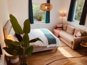 a living room with a bed and a couch at Geulzicht Hotel in Schin op Geul