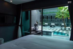 a bedroom with a bed and a view of a pool at foto Hotel Phuket in Phuket Town