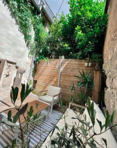 een kleine tuin met een stoel en een hek bij Loft atypique au calme avec cour privative in Bourges