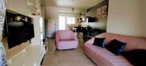 a living room with a pink couch and a chair at La Marquise in Flic-en-Flac