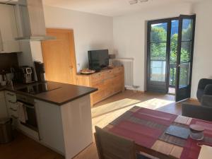 Walchensee-Idyll في فالشينسي: مطبخ وغرفة معيشة مع طاولة ومكتب