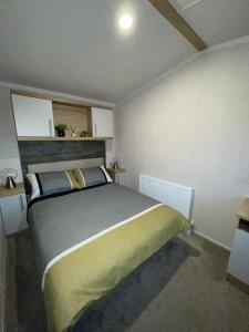 a bedroom with a large bed in a room at PRESTIGE GOLF VILLAGE CARAVAN in Port Seton
