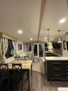 a kitchen and living room with a table and chairs at PRESTIGE GOLF VILLAGE CARAVAN in Port Seton