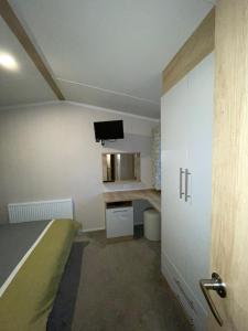 a bedroom with a bed and a tv on the wall at PRESTIGE GOLF VILLAGE CARAVAN in Port Seton