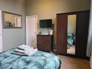 a bedroom with a bed and a mirror and a television at Hen House in Cannock