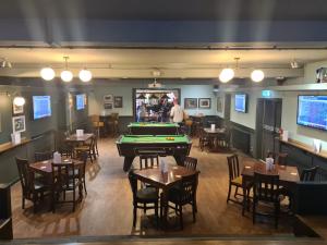 a restaurant with a pool table and tables and chairs at Hen House in Cannock