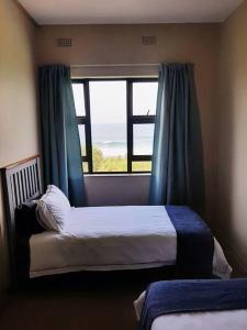 a bedroom with a bed and a large window at La Corsica Beach House Breakaway in Margate
