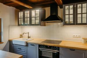 a kitchen with a sink and a stove at Kellerstöckl Berg 77 in Sumetendorf
