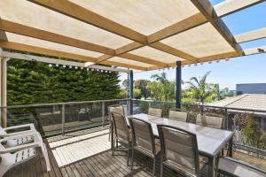 托基Torquay Sea Cret - BYO Linen的露台上有一张桌子和几把椅子