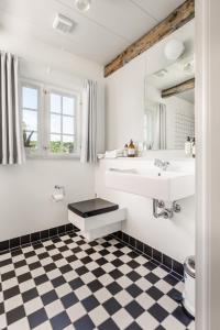 a bathroom with a sink and a checkered floor at Hindsgavl Slot in Middelfart