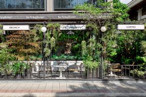a cafe with tables and chairs in front of a building at Volve Hotel Bangkok in Bangkok