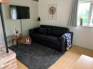 a living room with a black couch and a table at Hindsgavl Slot in Middelfart
