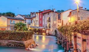 a canal in a town at dusk at Il Borghetto Vacanze nei Mulini in Valeggio sul Mincio