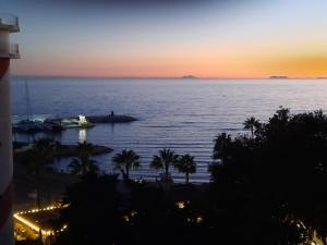 a sunset over the ocean with a boat in the water at Apto Puerto Deportivo el Faro Marbella in Marbella