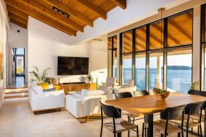 un soggiorno con tavolo in legno e mobili bianchi di Villa M - Dubrovnik a Zaton