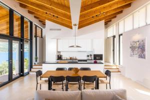 una cucina e una sala da pranzo con tavolo e sedie in legno di Villa M - Dubrovnik a Zaton