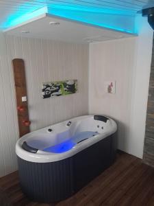 a large bath tub in a room with a blue light at spacieuse maison de ville avec espace détente in Rezé