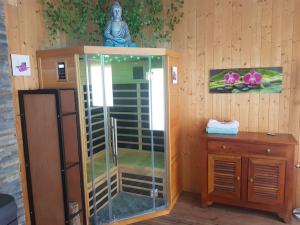 prysznic w pokoju z drewnianą ścianą w obiekcie spacieuse maison de ville avec espace détente w mieście Rezé