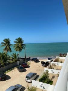 un estacionamiento con coches estacionados en la playa en Branco Haus - Pé na Areia do Caribessa, en João Pessoa