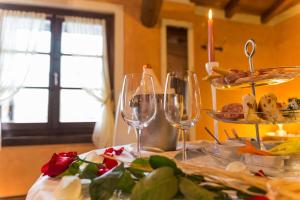 a table with wine glasses and a plate of food at Il Borghetto Vacanze nei Mulini in Valeggio sul Mincio