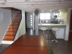 une cuisine avec un escalier et une cuisine avec des tabourets dans l'établissement spacieuse maison de ville avec espace détente, à Rezé