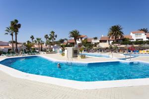 a pool at a resort with a person in the water at Eagle Studio in San Miguel de Abona