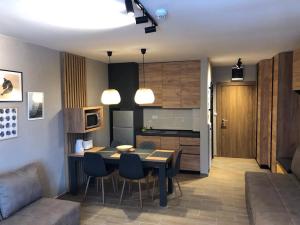 a kitchen and living room with a table and chairs at Apartmani A in Kopaonik