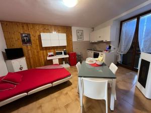 um quarto com uma cama, uma mesa e uma cozinha em Da Mara Lago Di Como em Sormano