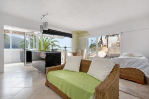 Un dormitorio con una cama y un sofá en una habitación. en Piso Loft tropical Doa, en San Marcos