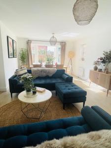 ein Wohnzimmer mit blauen Sofas und einem Tisch in der Unterkunft NEW! Beautiful contemporary property in Holt, Norfolk in Holt