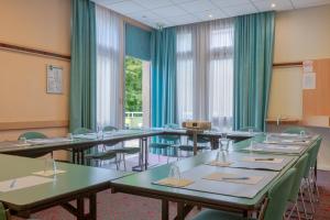 a conference room with tables and chairs and windows at B&B HOTEL Chartres Centre Cath&eacute;drale in Chartres