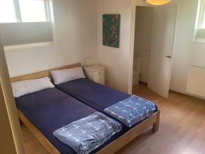 una camera da letto con un letto con lenzuola blu sopra di Fewo Am Deich a Fehmarn