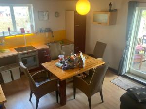 a small kitchen with a wooden table and chairs at Fewo Am Deich in Fehmarn