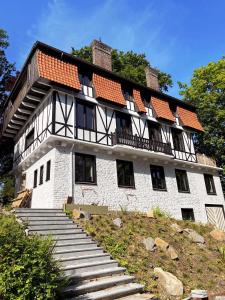 Un grand bâtiment avec des escaliers se trouve juste devant. dans l'établissement La Garçonnière Genval, à Rixensart