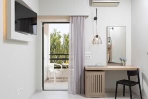 uma casa de banho com uma secretária e um espelho. em Paradise Hotel Corfu em Gouviá