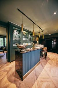 a bar in a room with green walls and wooden floors at La Garçonnière Genval in Rixensart